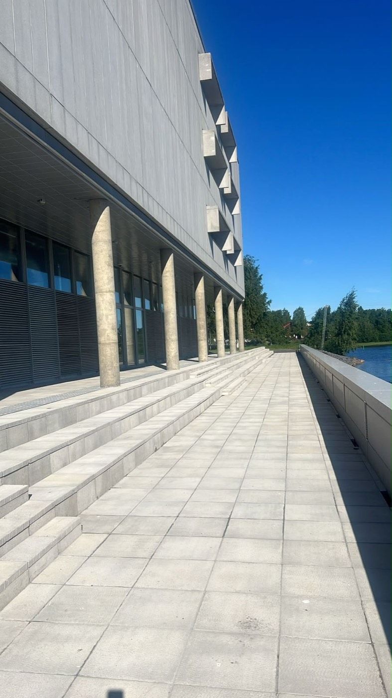 Leveät laattaportaat ja raitti rakennuksen ja rannan välissä